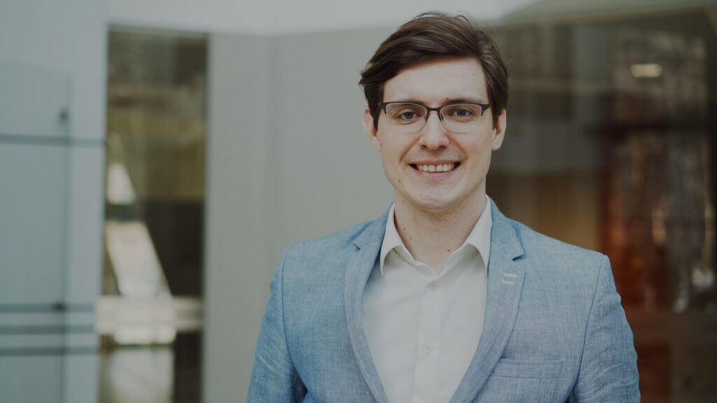 A smiling man in a suit and glasses
